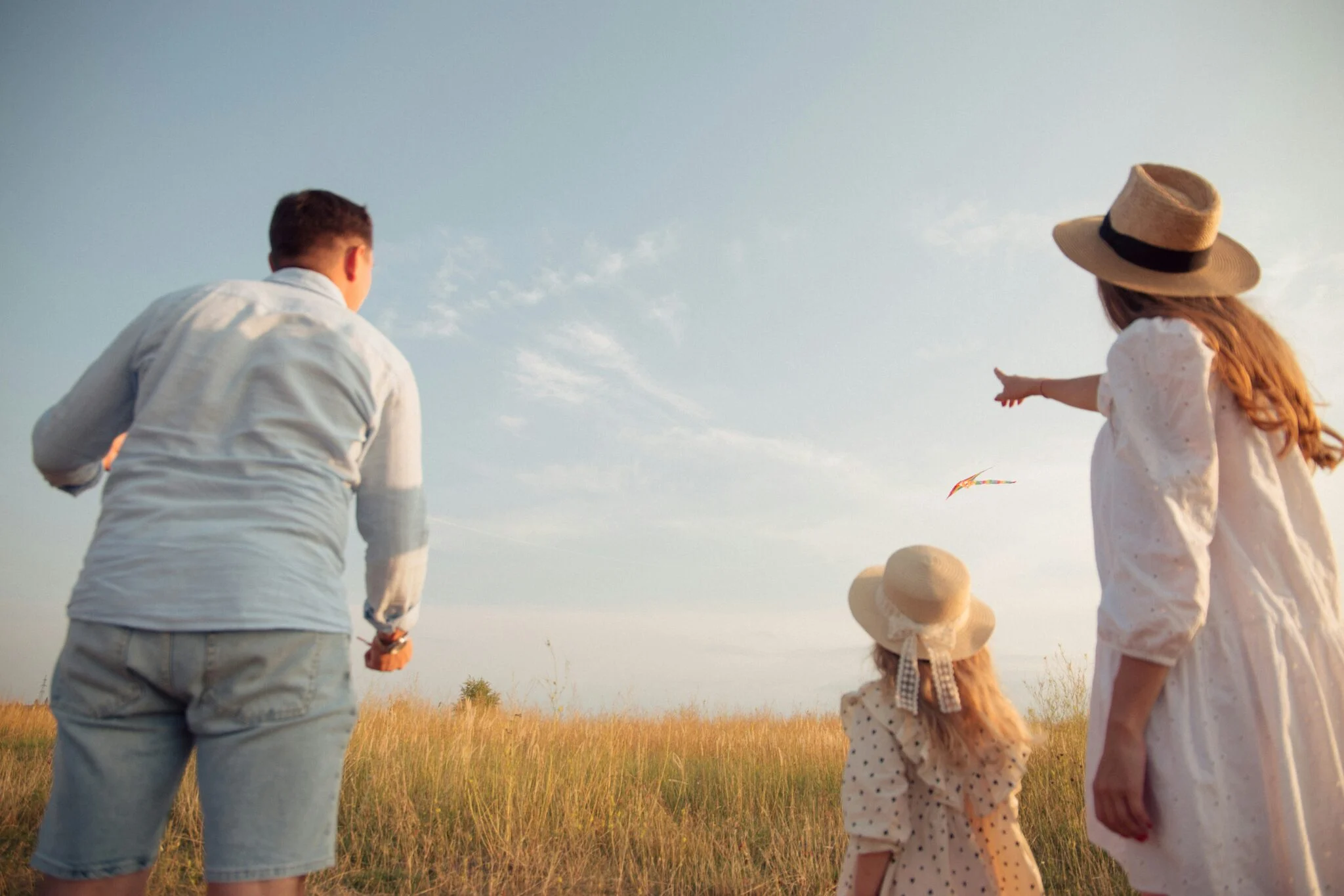 Family walking through a field at golden hour