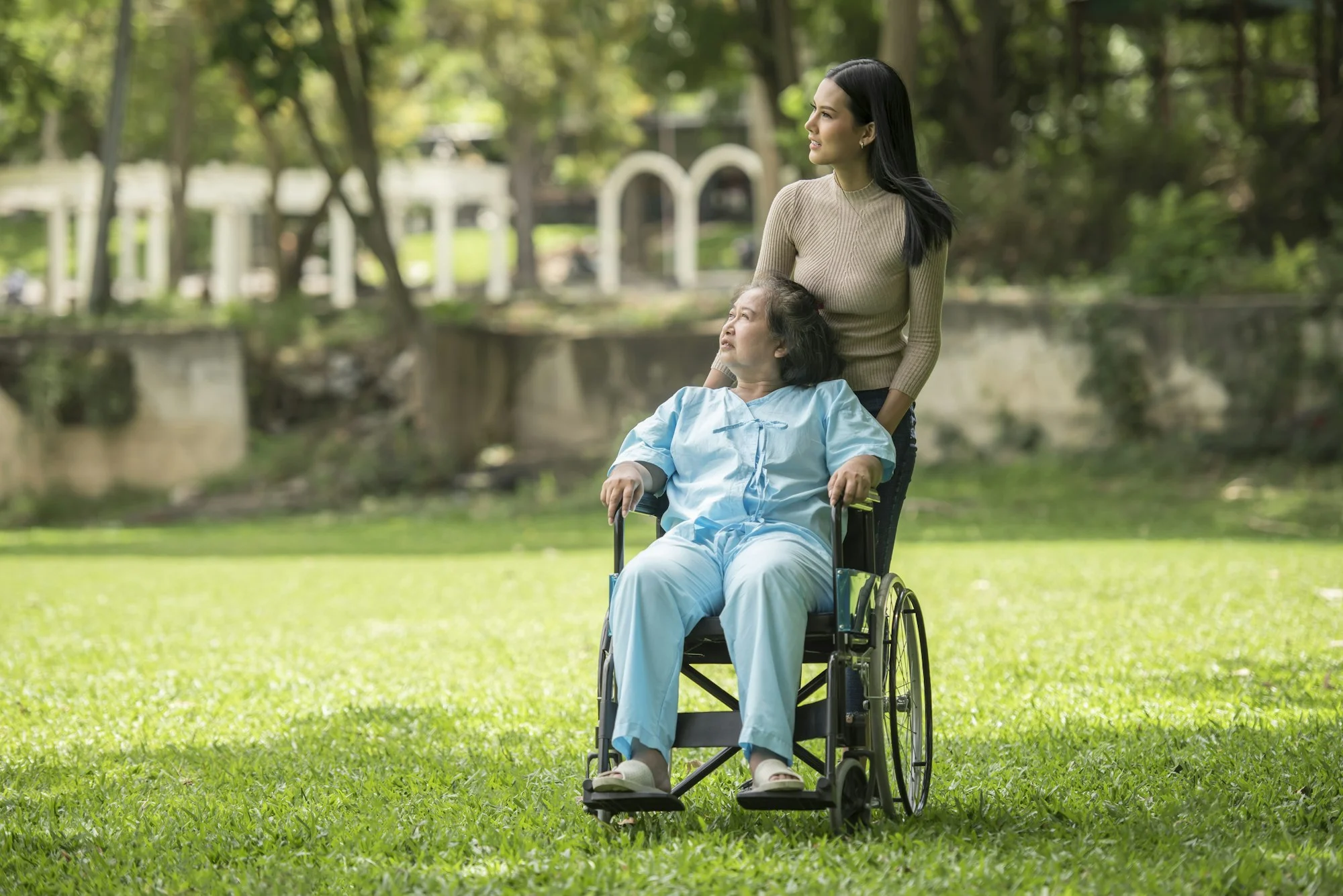 Support worker with a client in a wheelchair in a park, NDIS provider insurance