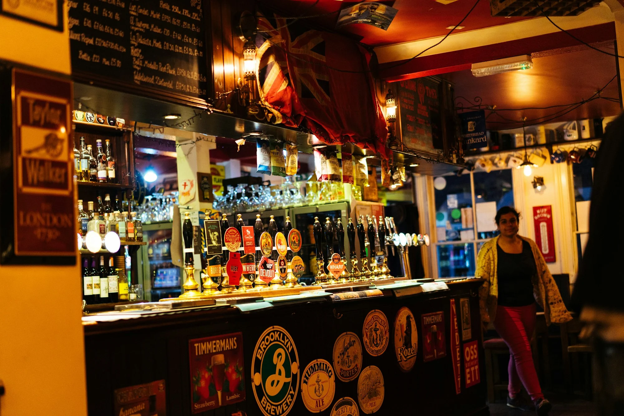 Busy pub bar with beer taps and bottles, pub and bar insurance Melbourne