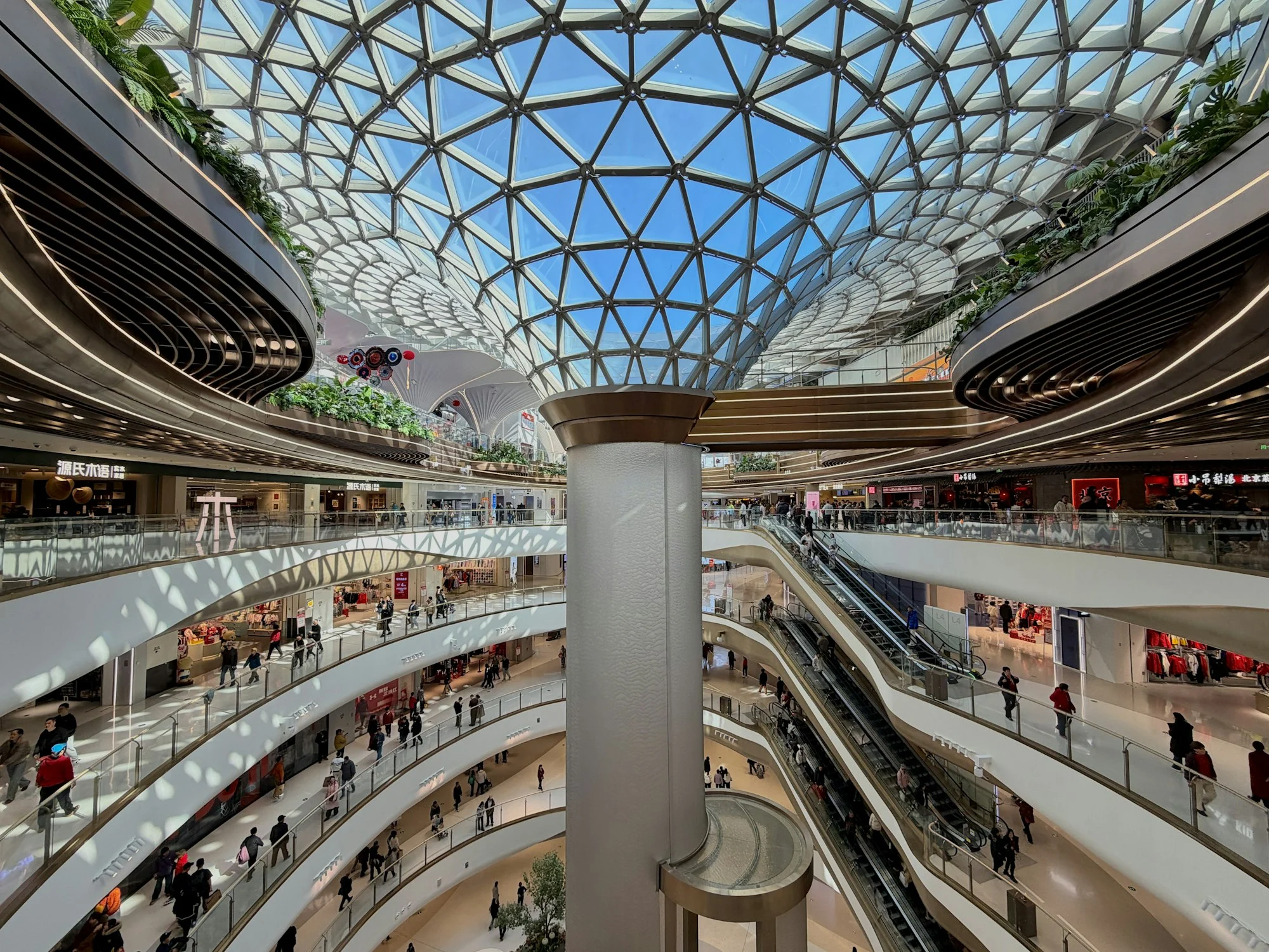 Multi-level shopping centre with escalators and shoppers, shopping centre insurance